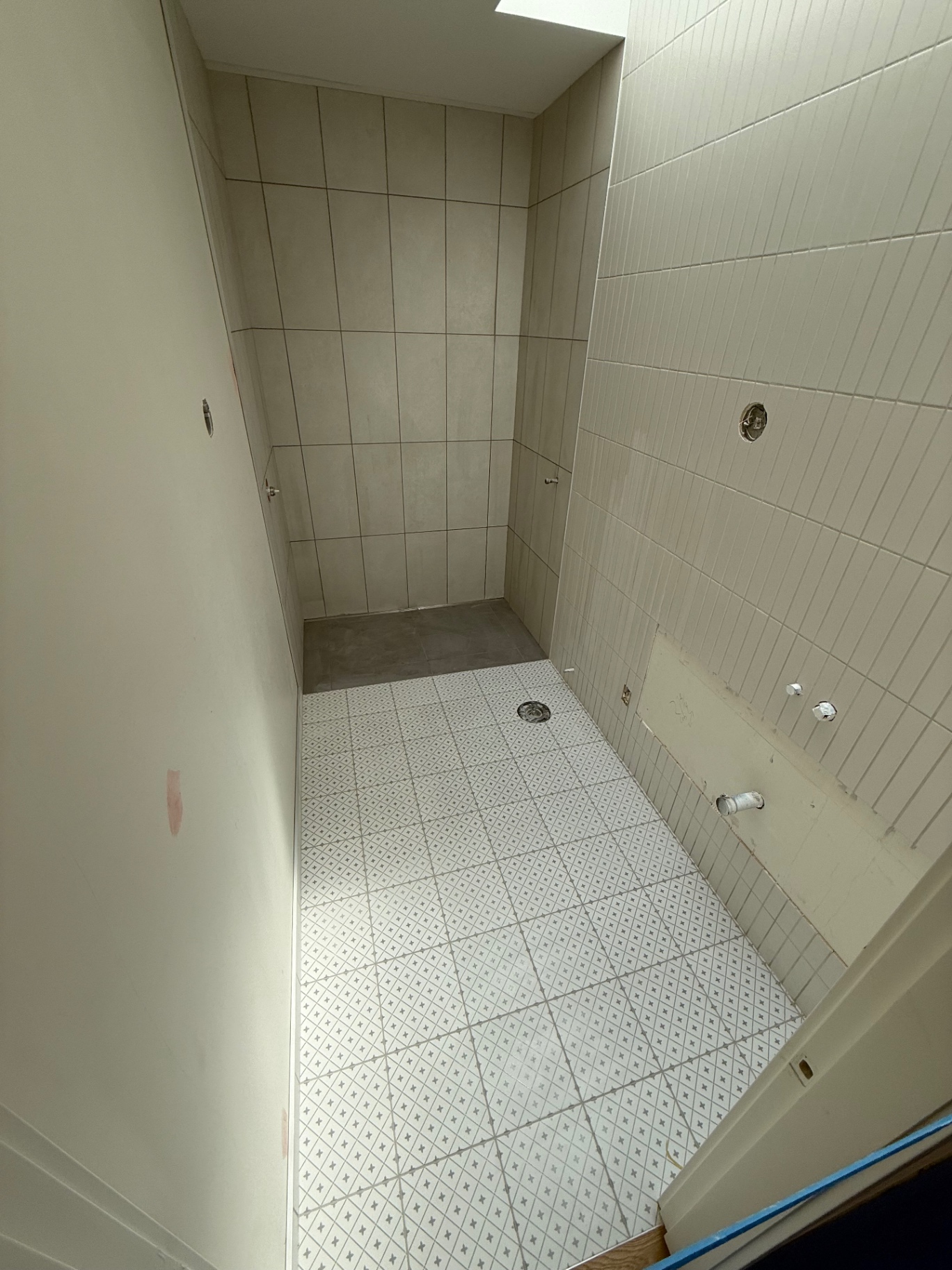 Patterned white floor tile with linear drain