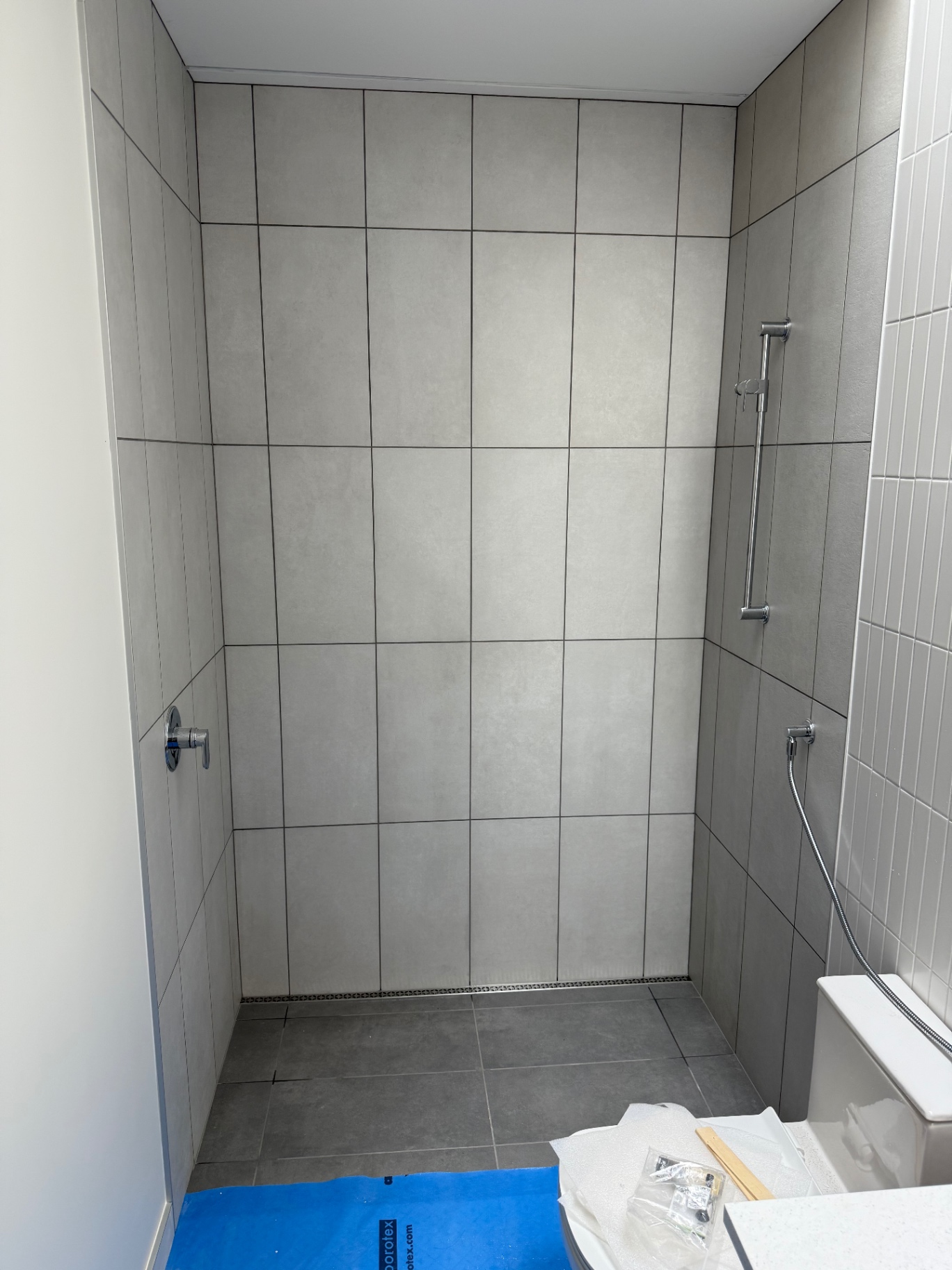 Stack-bonded large format grey porcelain shower